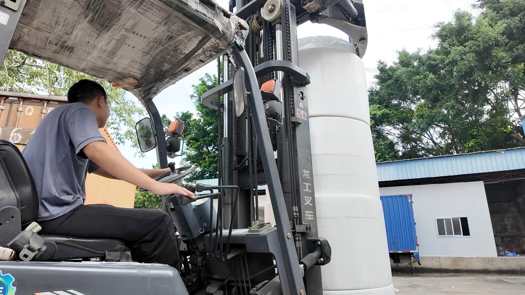 Jiufeng worker operating a forklift beside a wrapped parent tissue roll in the factory yard