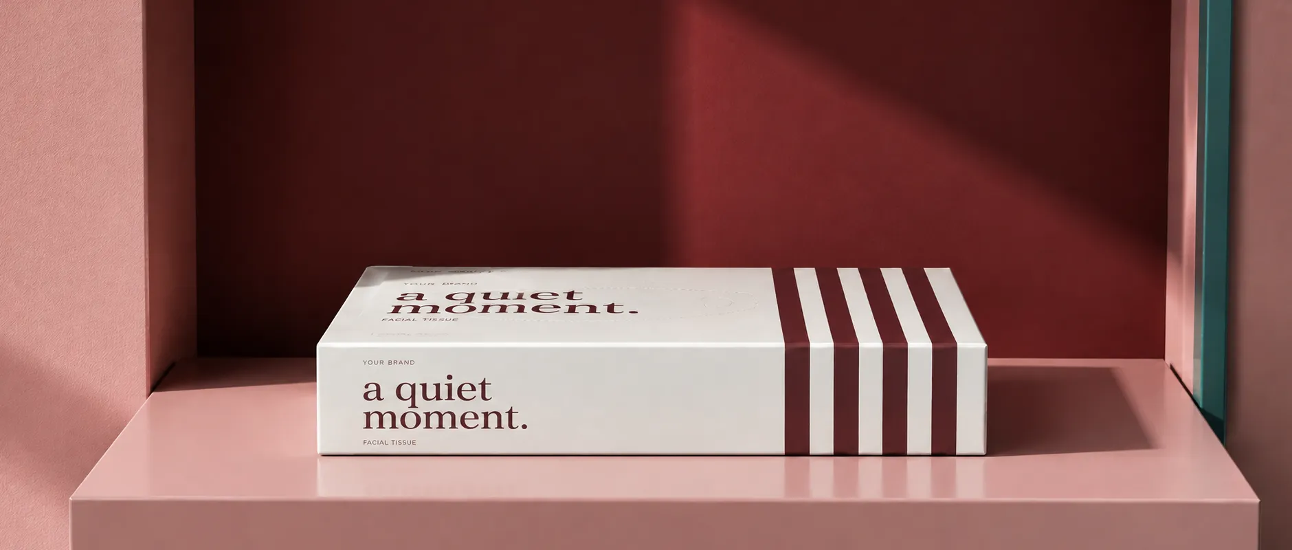 White and burgundy striped tissue packaging with a quiet moment lettering in a rose architectural setting
